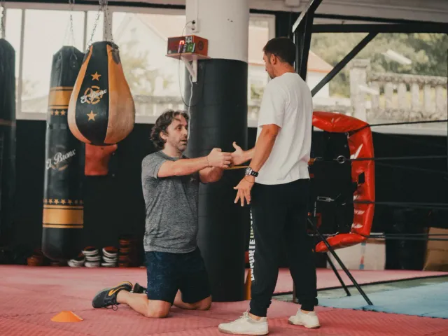 El entrenador corrigiendo la técnica de un alumno