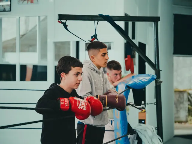 Niños con guantes esperando junto al ring