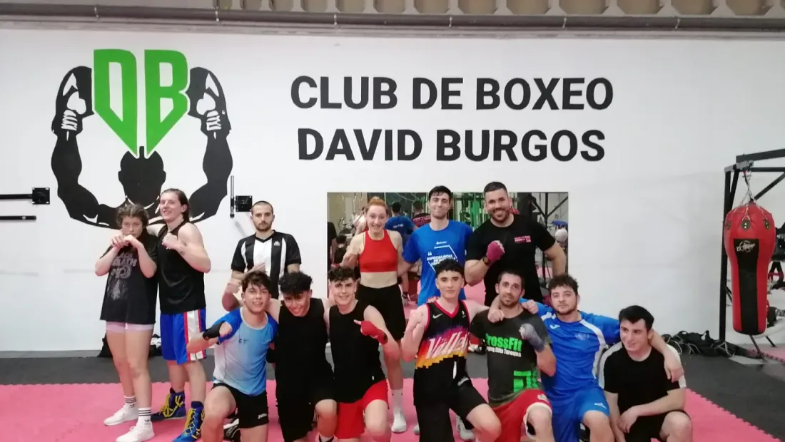 Grupo de atletas del club posando en equipo bajo el logo del Club de Boxeo David Burgos